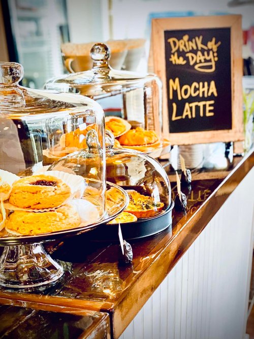 A display of pastries under glass domes next to a chalkboard sign for a mocha latte special.