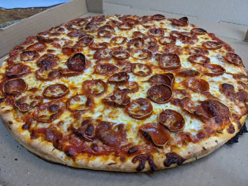 A large pepperoni pizza with a golden crust and melted cheese, placed in a pizza box.
