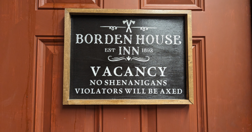 Sign on a door reading "Borden House Inn 1892, Vacancy, No Shenanigans, Violators Will Be Axed."