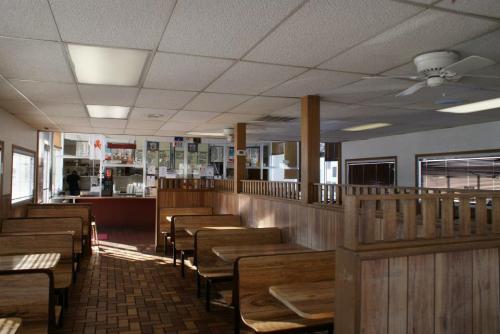 Interior of a casual dining restaurant with wooden benches, a counter, and large windows. Brightly lit and spacious.