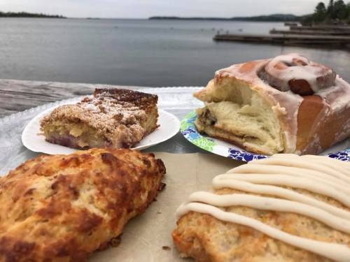 A variety of baked goods on a plate, with a scenic lake view in the background.