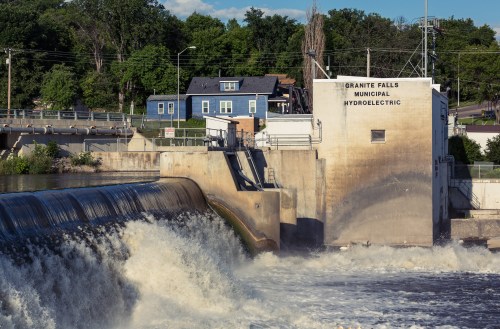 Hydroelectric dam at Granite Falls with water cascading over the edge and a building labeled "Granite Falls Municipal Hydroelectric."