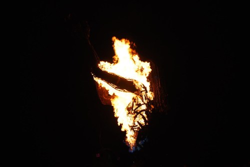 A bright flame engulfing a dark area, creating a dramatic contrast against the night sky.