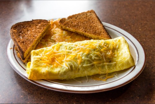A plate with a cheese omelet and two slices of toasted bread.