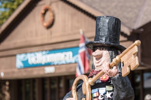 A whimsical statue of a man in a top hat holding a key, in front of a building with a sign that reads "Gellerman."
