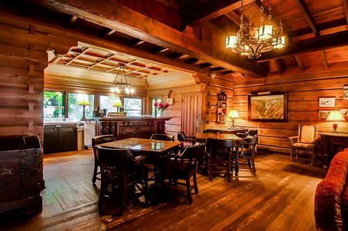 Cozy wooden interior of a rustic cabin with dining tables, a bar area, and warm lighting.