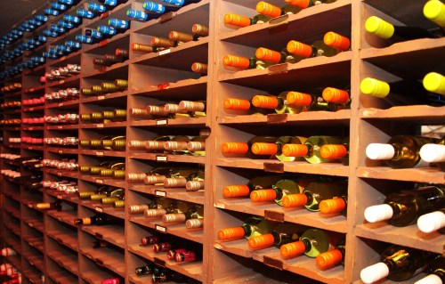 A wine cellar with neatly arranged shelves filled with various bottles of wine in different colors and sizes.