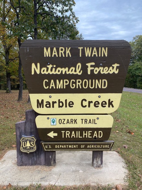 Sign for Mark Twain National Forest Campground at Marble Creek, featuring Ozark Trail and trailhead information.