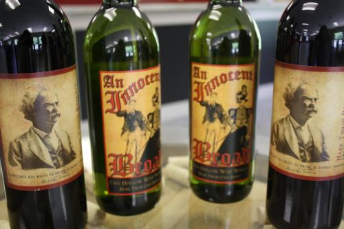 Four wine bottles with vintage-style labels featuring portraits and the text "An Innocent Broad."
