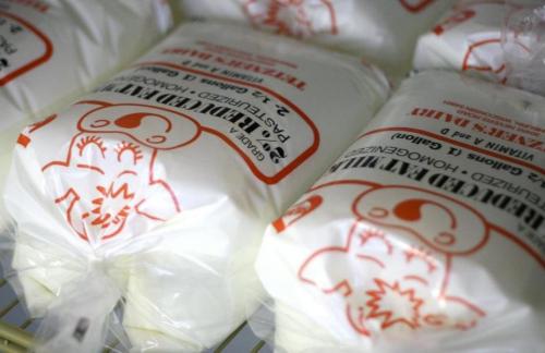 Packages of frozen milk with cartoon character branding, labeled with nutritional information and storage instructions.