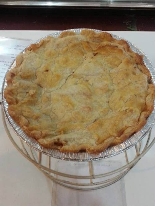 A freshly baked pie with a golden, flaky crust, displayed on a wire rack.