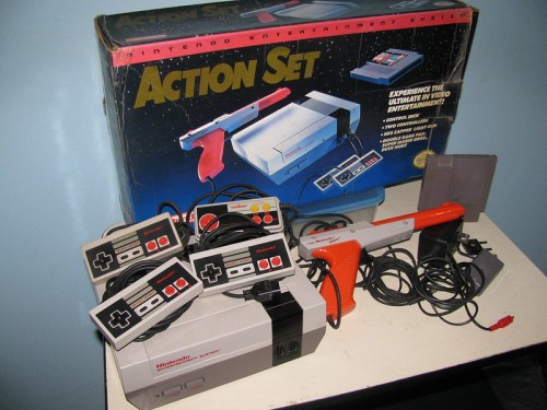 A Nintendo Action Set with a console, controllers, and a light gun, displayed next to its original box.
