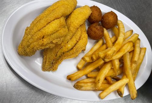 A white plate with golden fried catfish fillets, crispy French fries, and two hushpuppies.