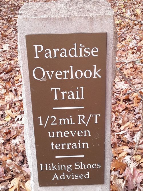 Sign for Paradise Overlook Trail: 1/2 mile round trip, uneven terrain, hiking shoes advised. Surrounded by fallen leaves.