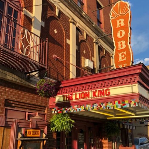 The Robey Theater marquee displays "The Lion King" with colorful decorations and a vintage sign.