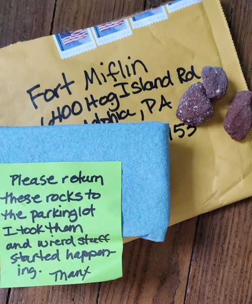 A yellow envelope with a note and rocks, asking to return the rocks to the parking lot where they were taken.
