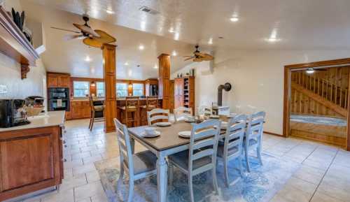 A spacious kitchen and dining area with a large table, wooden cabinets, and modern appliances. Bright and inviting atmosphere.