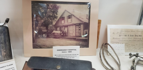 Historic photo of an emergency hospital from 1880, featuring a building and horse-drawn ambulance.