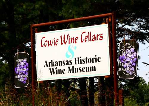 Sign for Cowie Wine Cellars and Arkansas Historic Wine Museum, featuring grape-themed decorations.