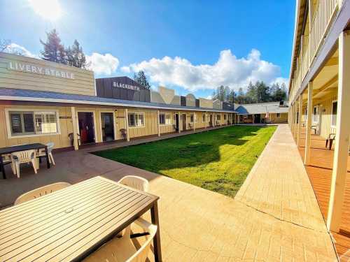 A sunny courtyard with buildings labeled "Livery Stable" and "Blacksmith," surrounded by green grass and blue skies.