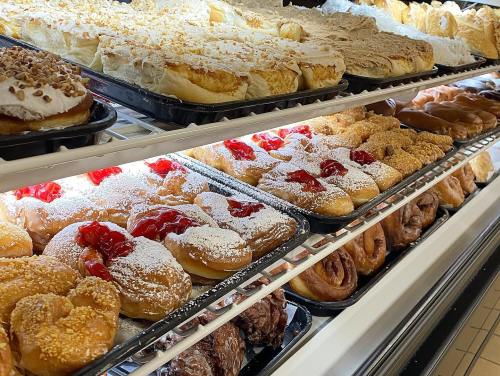 A display of assorted pastries and donuts, including cream-filled, frosted, and fruit-topped varieties.