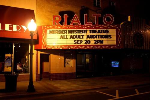 Marquee of the Rialto Theatre at night, advertising "Murder Mystery Theatre" auditions on September 20 at 2 PM.