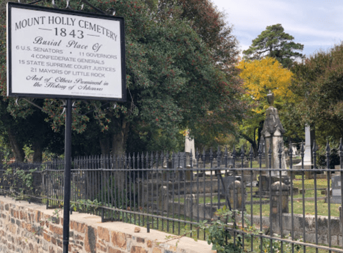 Sign at Mount Holly Cemetery, established in 1843, listing notable burials including senators, governors, and justices.