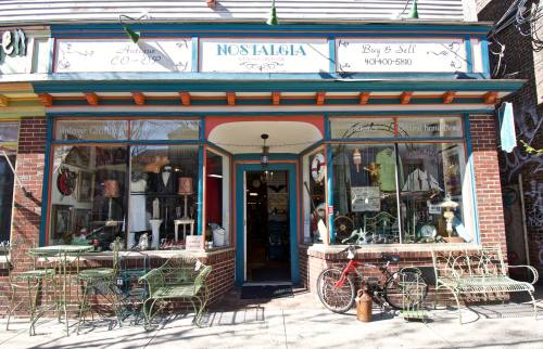 A charming antique shop named "Nostalgia" with vintage items displayed outside and a red bicycle in front.