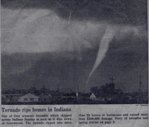 Black and white newspaper image showing a tornado touching down in Indiana, with houses in the foreground and dark clouds above.