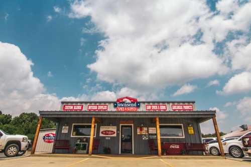 A small, rustic building with a sign reading "Townsend" and various business names, under a blue sky with clouds.