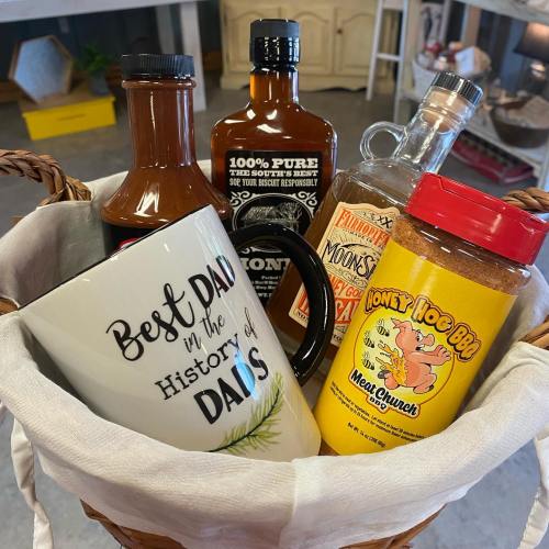 A basket filled with various bottles and a mug that says "Best Dad in the History of Dads."