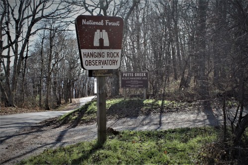 Sign for Hanging Rock Observatory in a national forest, with a road fork and another sign for Potts Creek nearby.