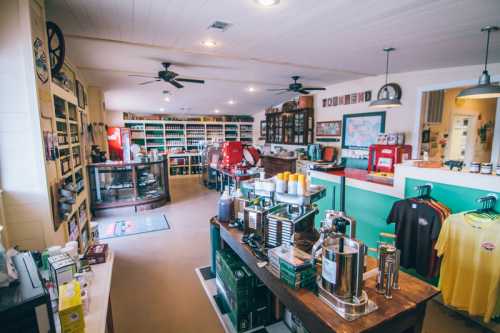 A cozy shop interior with shelves of products, a wooden counter, and a coffee station, featuring warm lighting and a welcoming atmosphere.