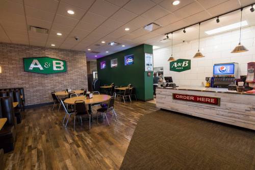 Interior of A&B Pizza restaurant featuring seating, a counter with a menu, and a drink station.