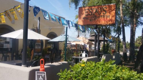 Exterior of Espo's restaurant with outdoor seating, colorful banners, and a sign reading "Authentic Mexican Food."