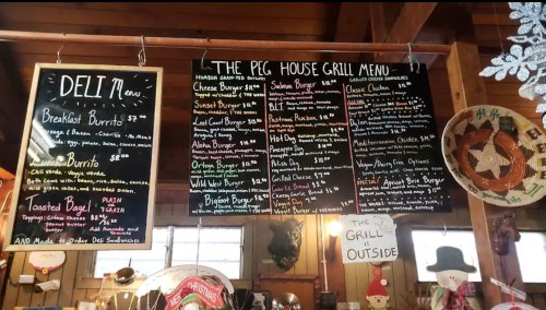 Chalkboard menu featuring deli and grill items, including burgers, burritos, and breakfast options in a rustic setting.