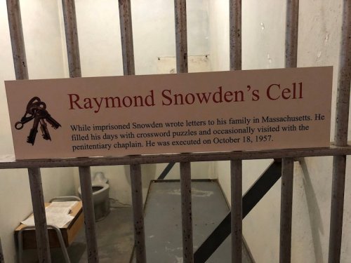 Sign on a prison cell door detailing Raymond Snowden's life, including letters to family and his execution date, October 18, 1957.