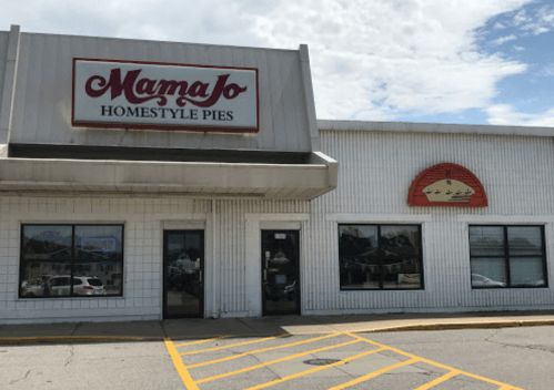 Exterior of Mama Jo's Homestyle Pies shop, featuring a sign and large windows on a sunny day.