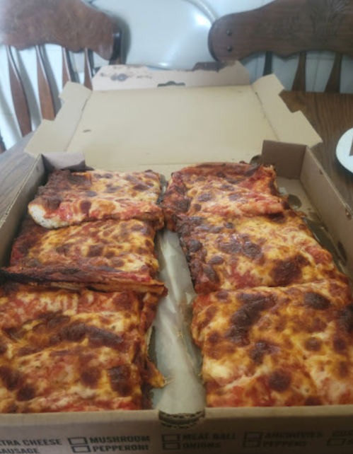 A pizza box opened to reveal several slices of pizza with melted cheese and various toppings.