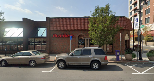 Exterior view of a Red Robin restaurant with a brick facade and a parked SUV in front.