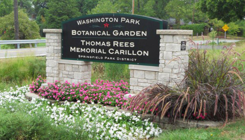 Sign for Washington Park Botanical Garden, featuring flowers and greenery, with "Thomas Rees Memorial Carillon" noted.