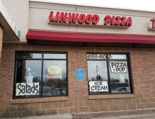 Exterior of Linwood Pizza, featuring a red awning, large windows with signs for pizza, salads, ice cream, and a handicap symbol.