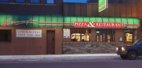 Exterior of Sammy's Pizza & Restaurant, featuring a green and red sign, with a lunch buffet banner and a parked blue truck.