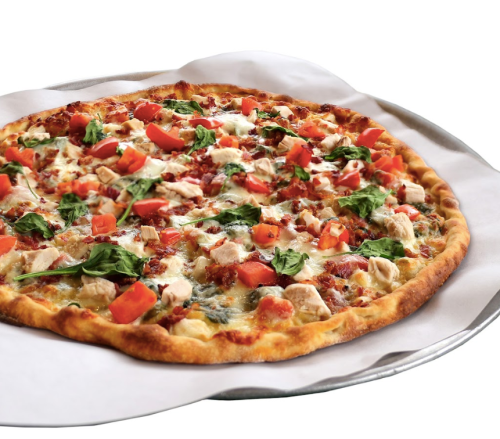 A freshly baked pizza topped with chicken, red peppers, spinach, and cheese on a round silver tray.