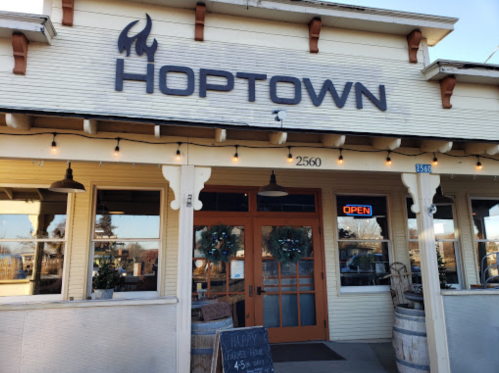 Exterior of Hoptown restaurant with a welcoming entrance, open sign, and festive decorations.