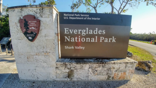 Sign for Everglades National Park at Shark Valley, featuring the National Park Service logo and park information.
