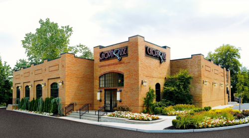 Exterior view of a brick restaurant building with landscaped gardens and a sign reading "Chop House."