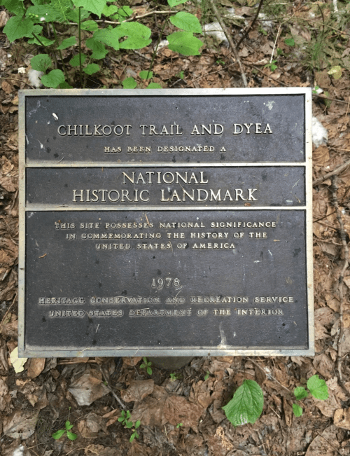Plaque designating Chilkoot Trail and Dyea as a National Historic Landmark, highlighting its historical significance.