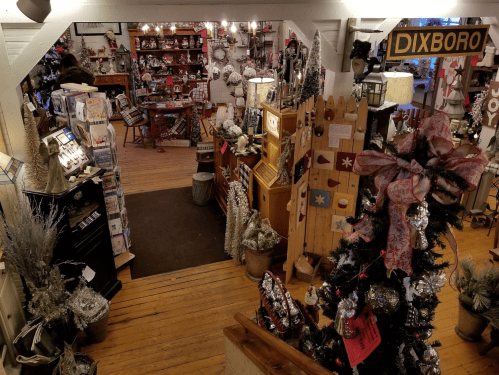 A cozy shop filled with holiday decorations, including a decorated tree and various festive ornaments.