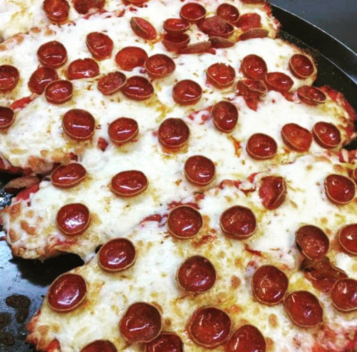A close-up of a pizza topped with melted cheese and numerous slices of pepperoni.